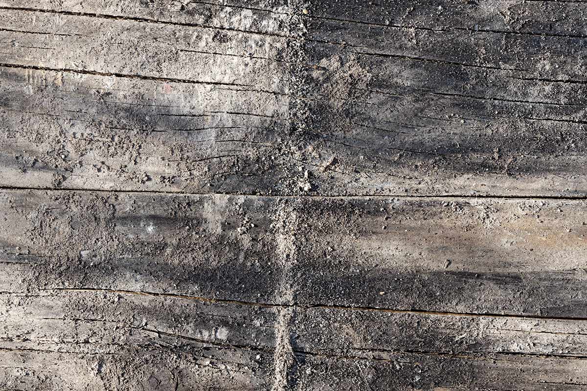 Bauholztextur mit Quarzsand und Zementanhaftungen